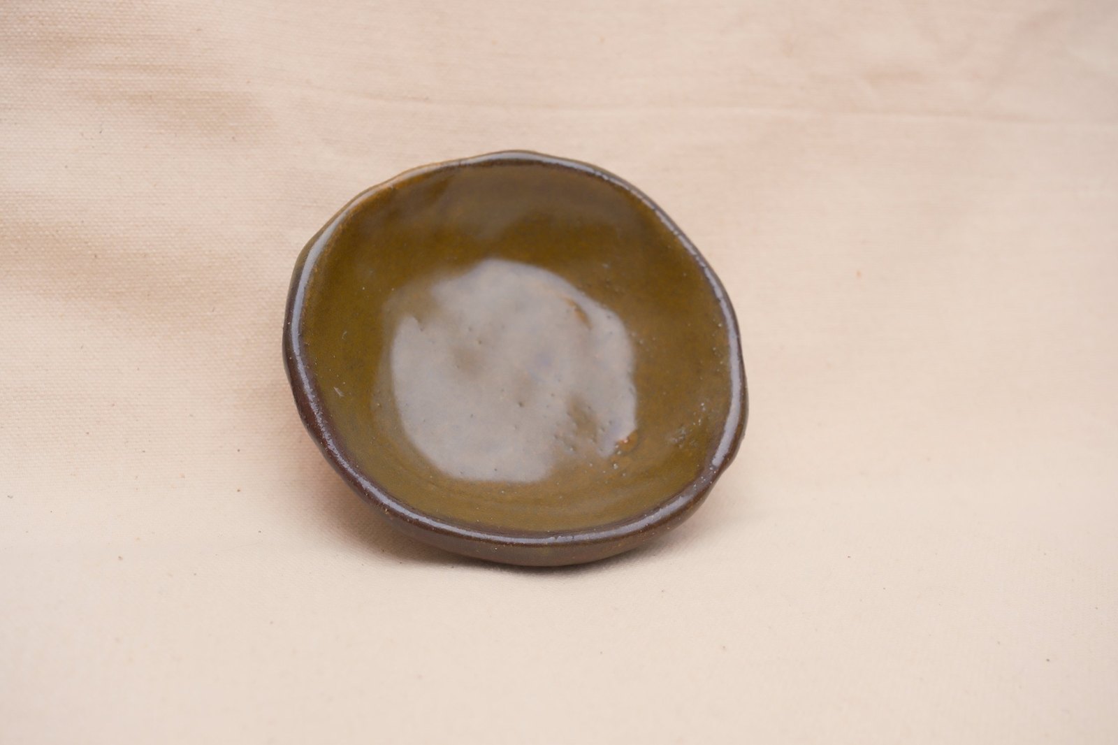 Looking down into the dish, glossy olive-gold glaze