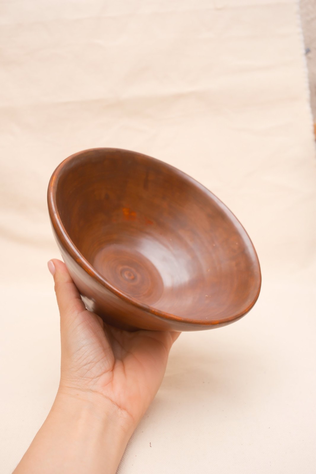 The flared bowl held in one hand, showing its size