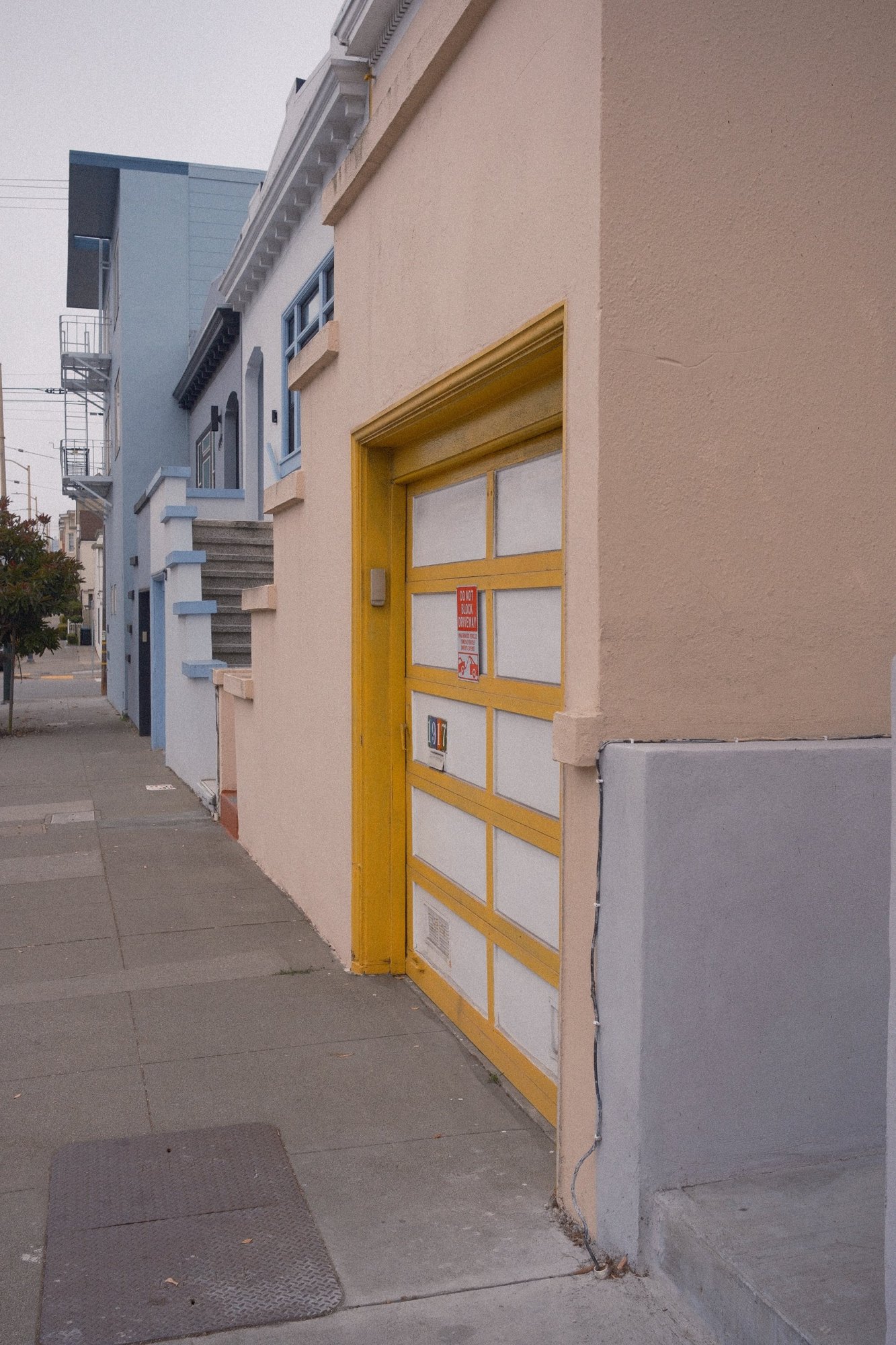 A yellow-framed garage door on a peach stucco house