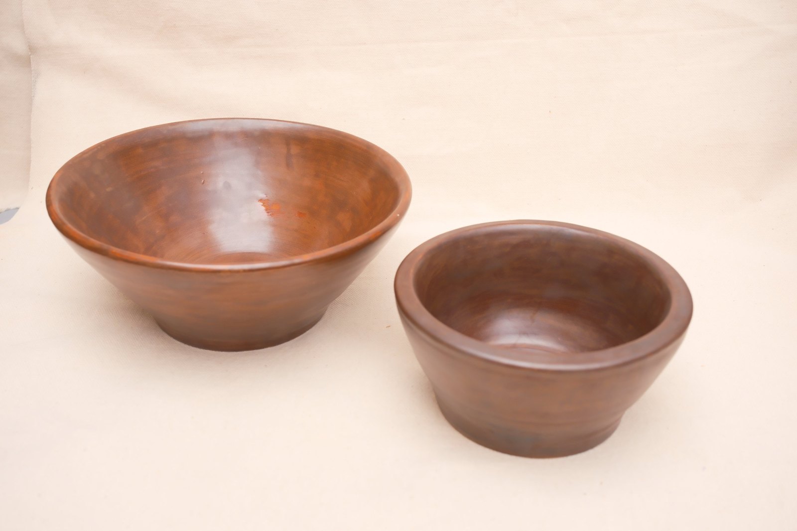 Both walnut bowls side by side on linen