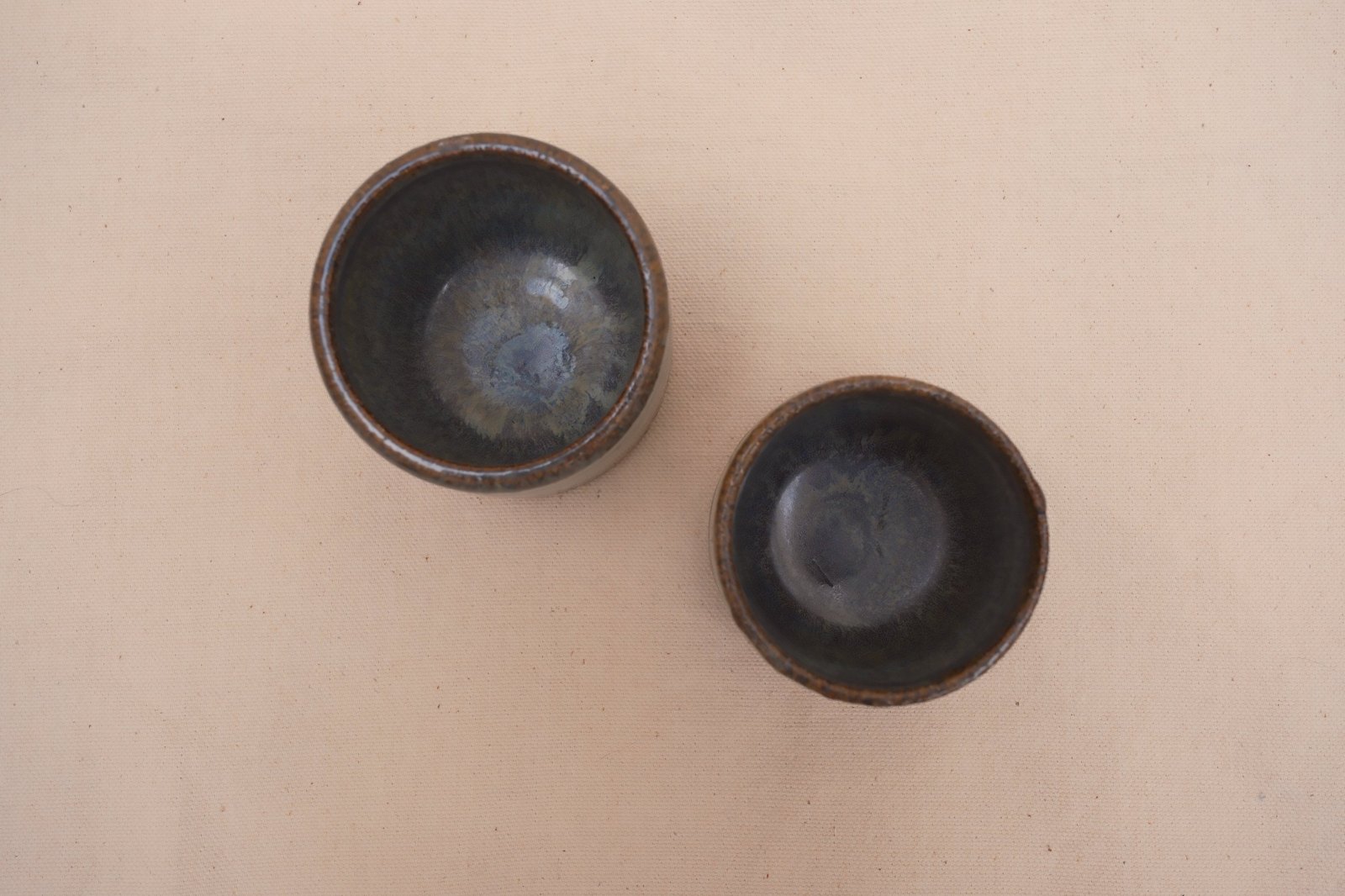Looking down into both cups at the pooled blue glaze inside