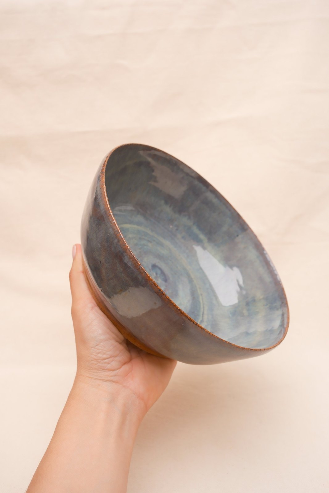 The bowl held up in one hand, showing its size and glossy interior