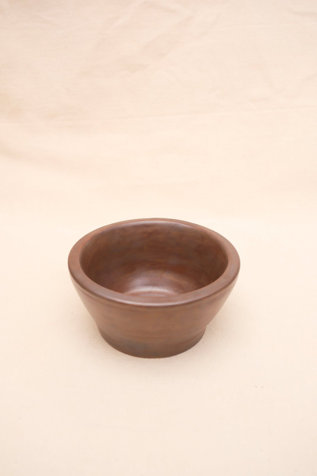 Thick-rimmed bowl in Black Walnut glaze, on linen