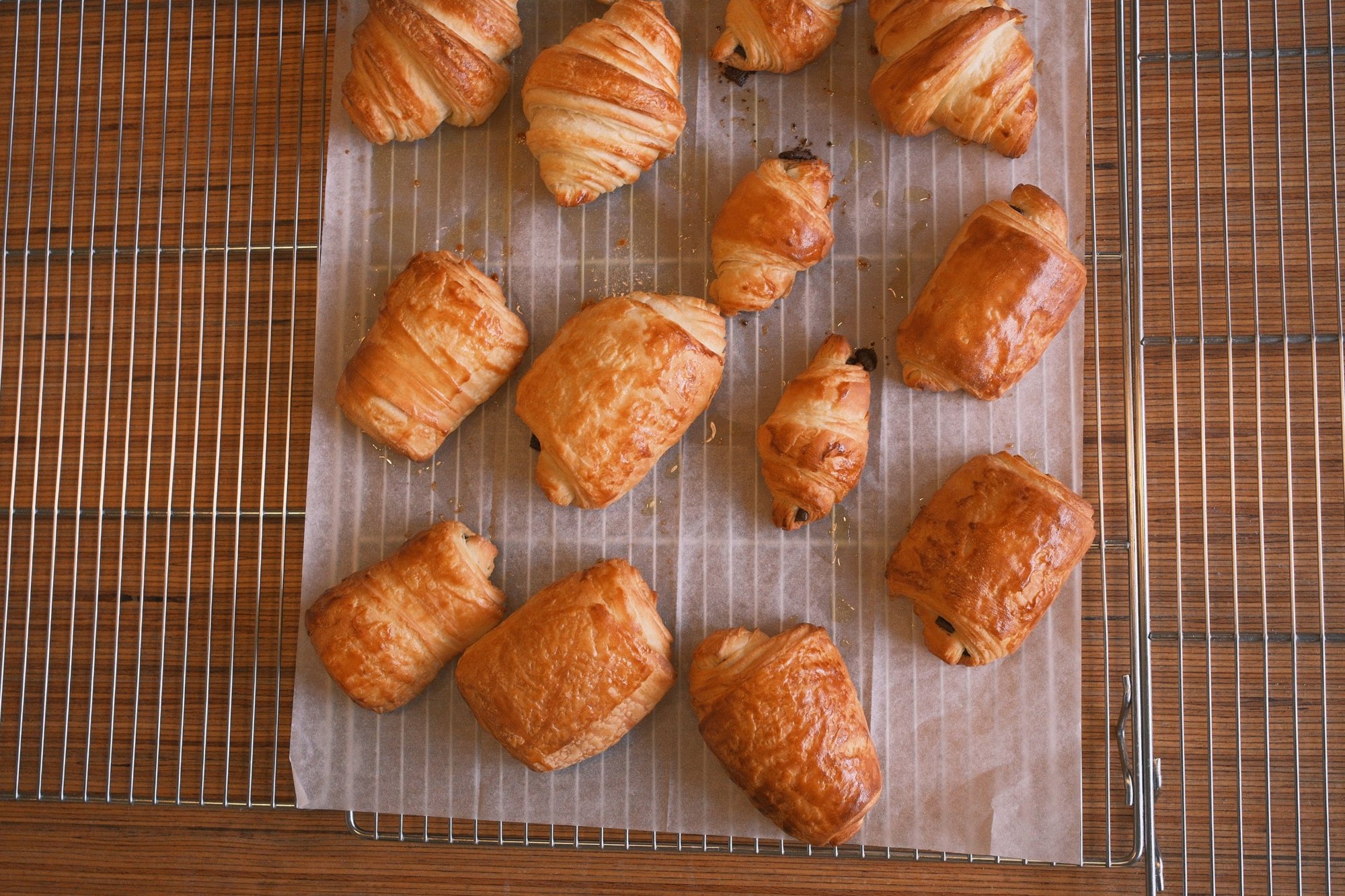 Fresh croissants and pain au chocolat cooling on a wire rack