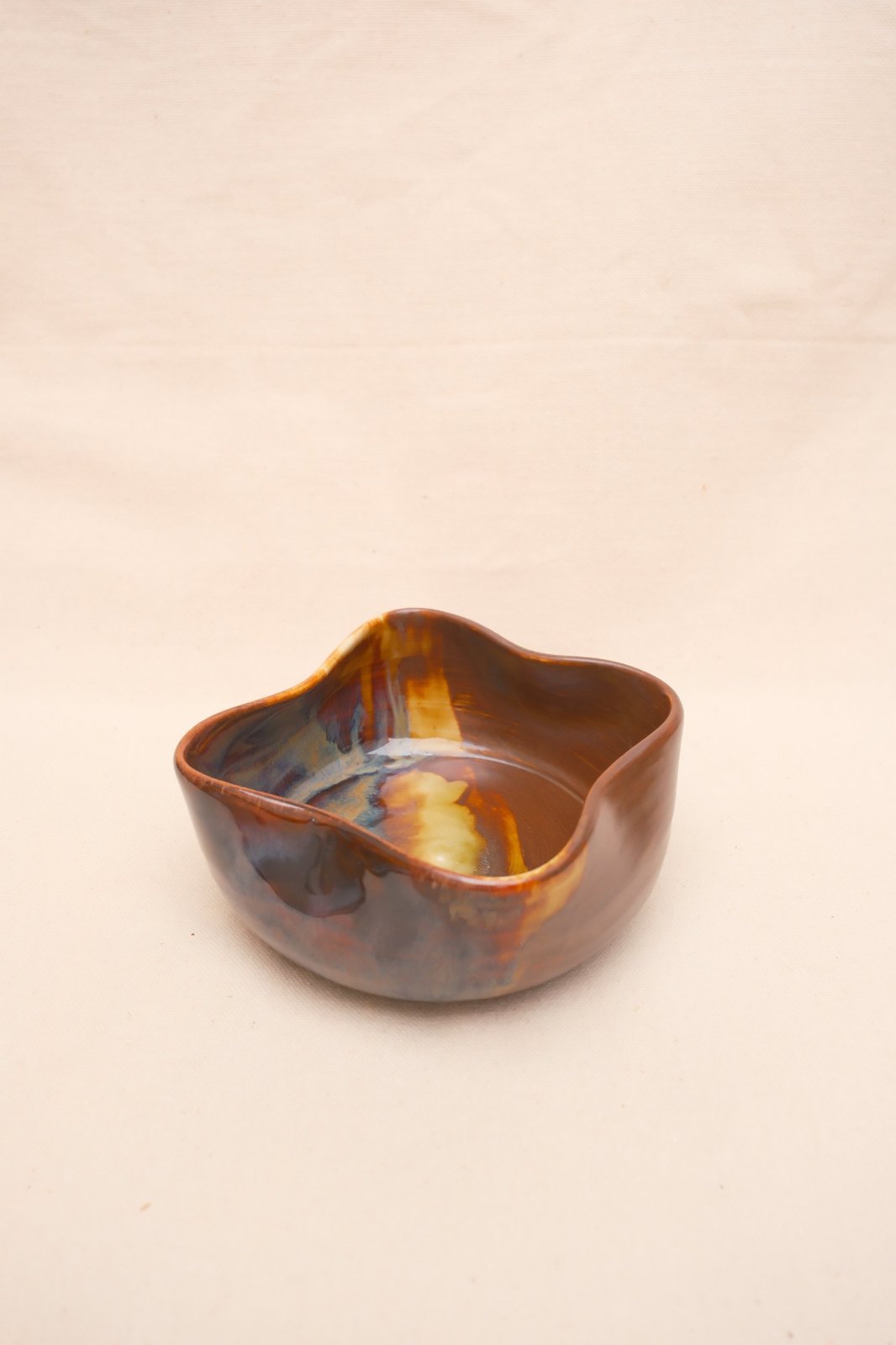 Wavy-rimmed bowl in Black Walnut and Tiger's Eye, on linen