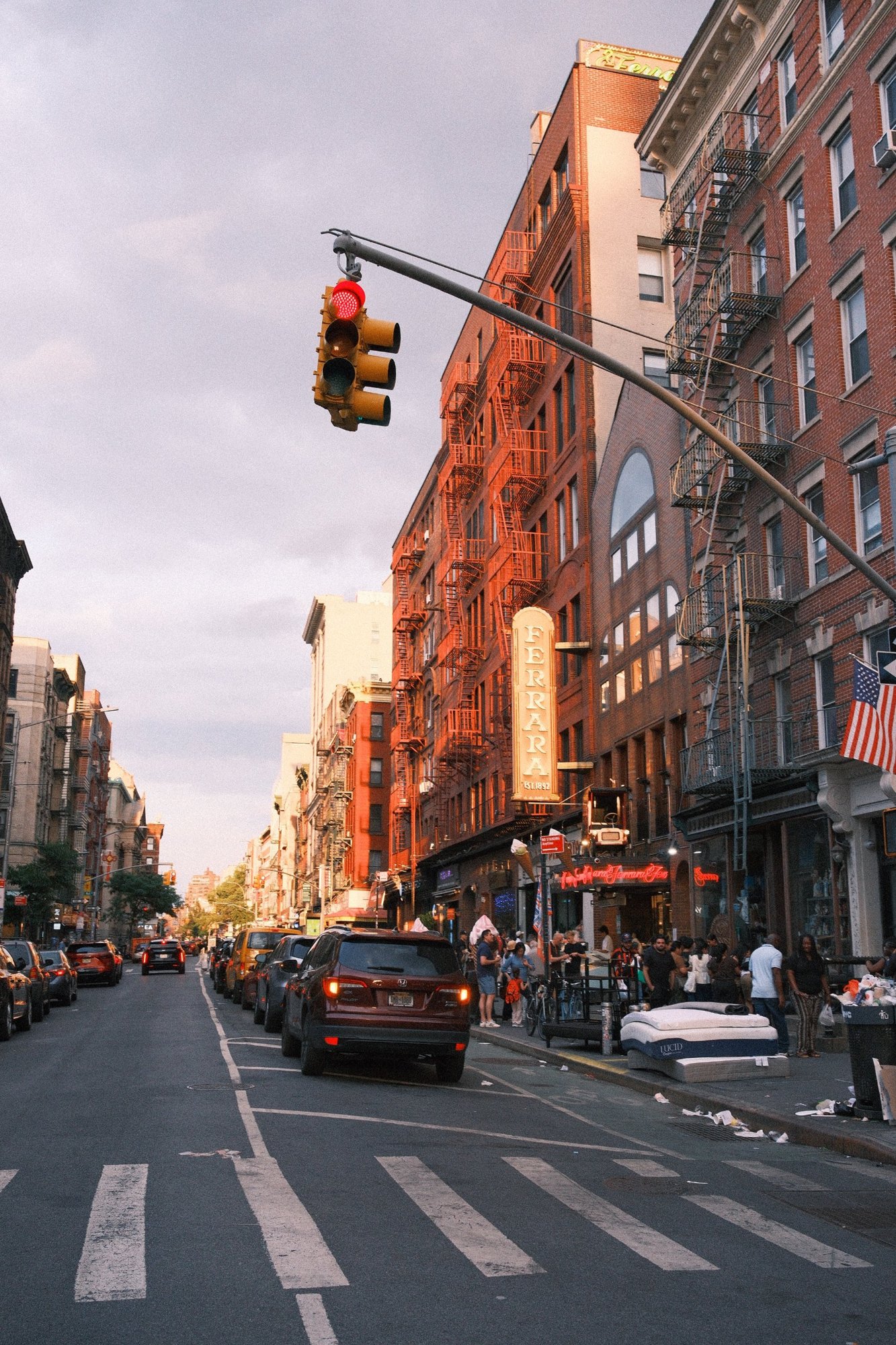 Golden-hour light on fire escapes and the Ferrara sign on Grand Street