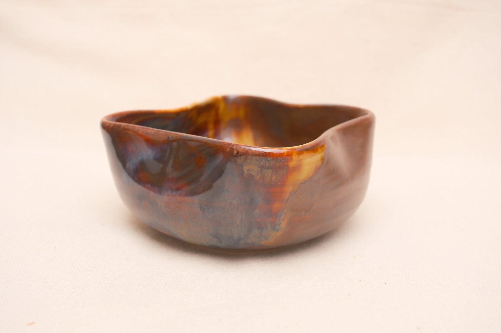 Low side view of the bowl, glossy glaze over chestnut brown