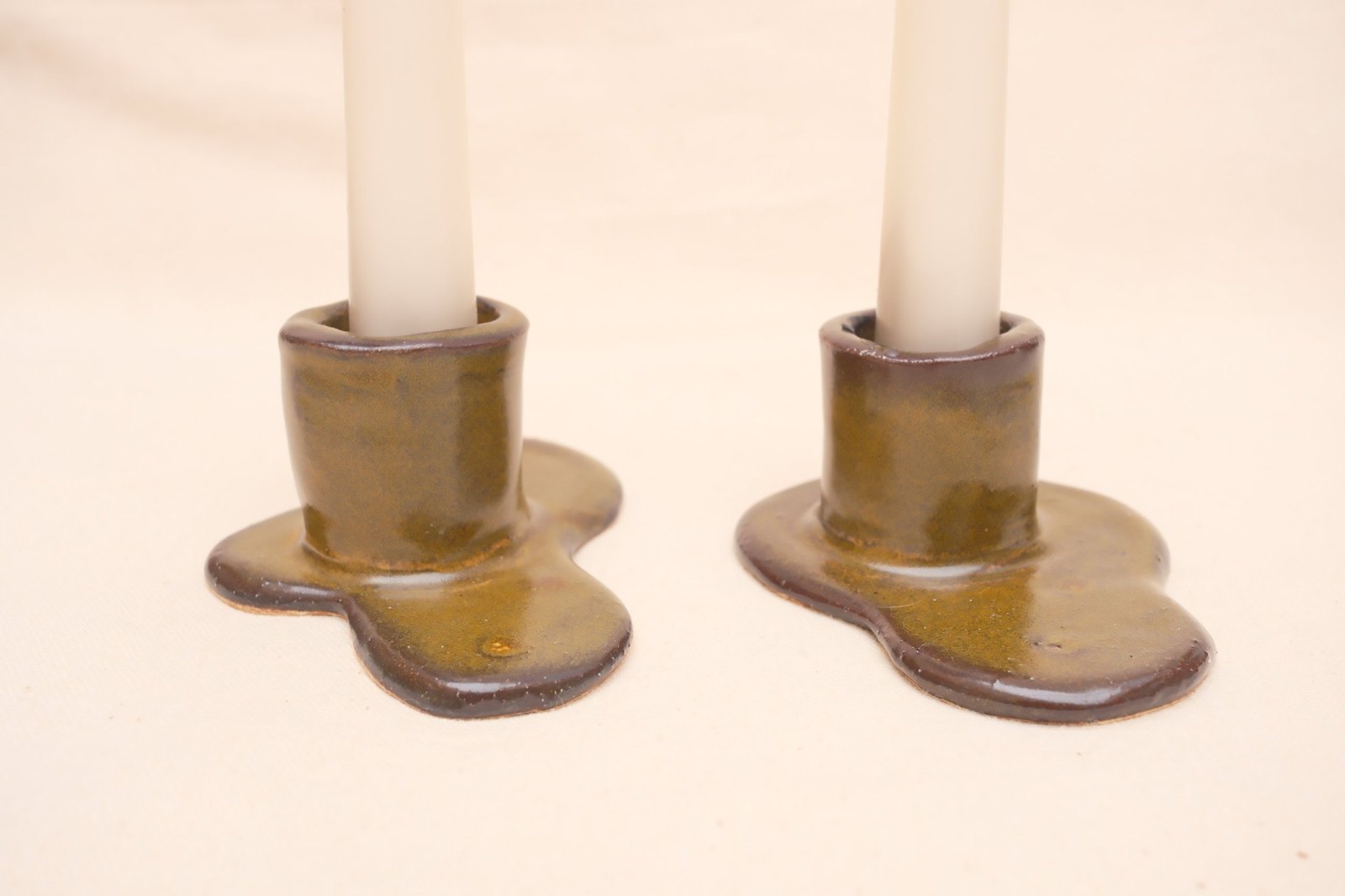 Close view of both holders, glaze breaking from olive to dark brown at the edges