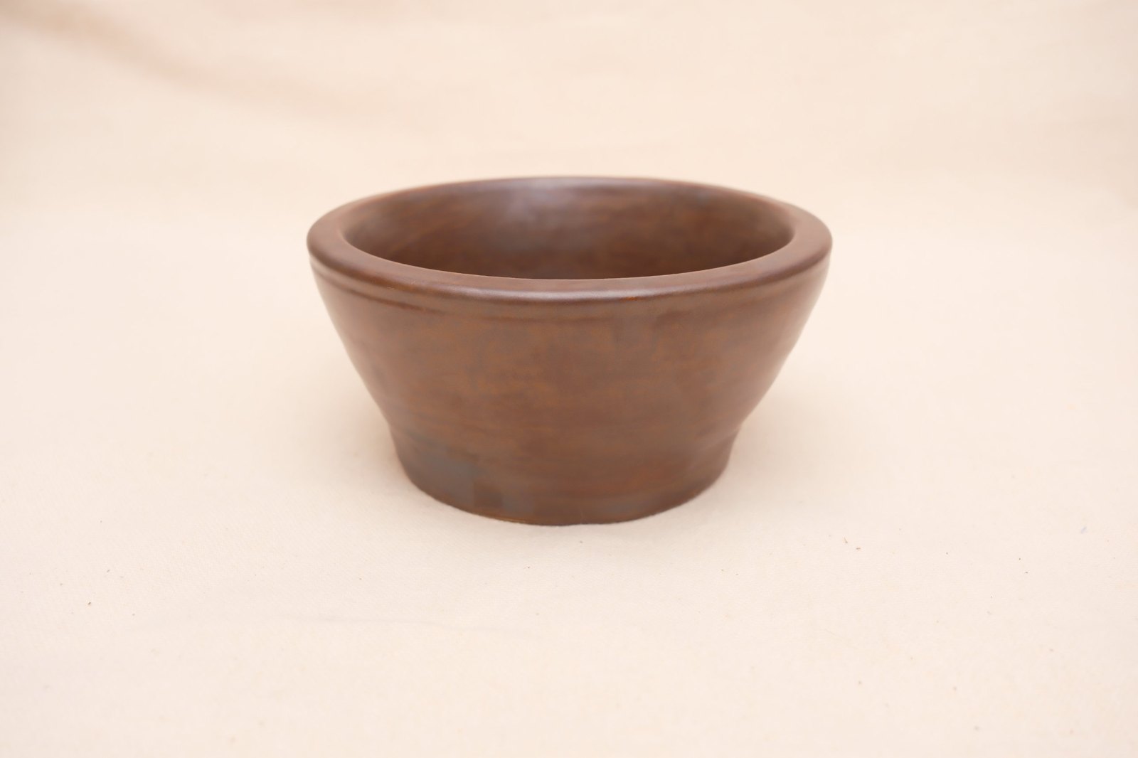 The bowl straight on, its flared walls and narrow foot