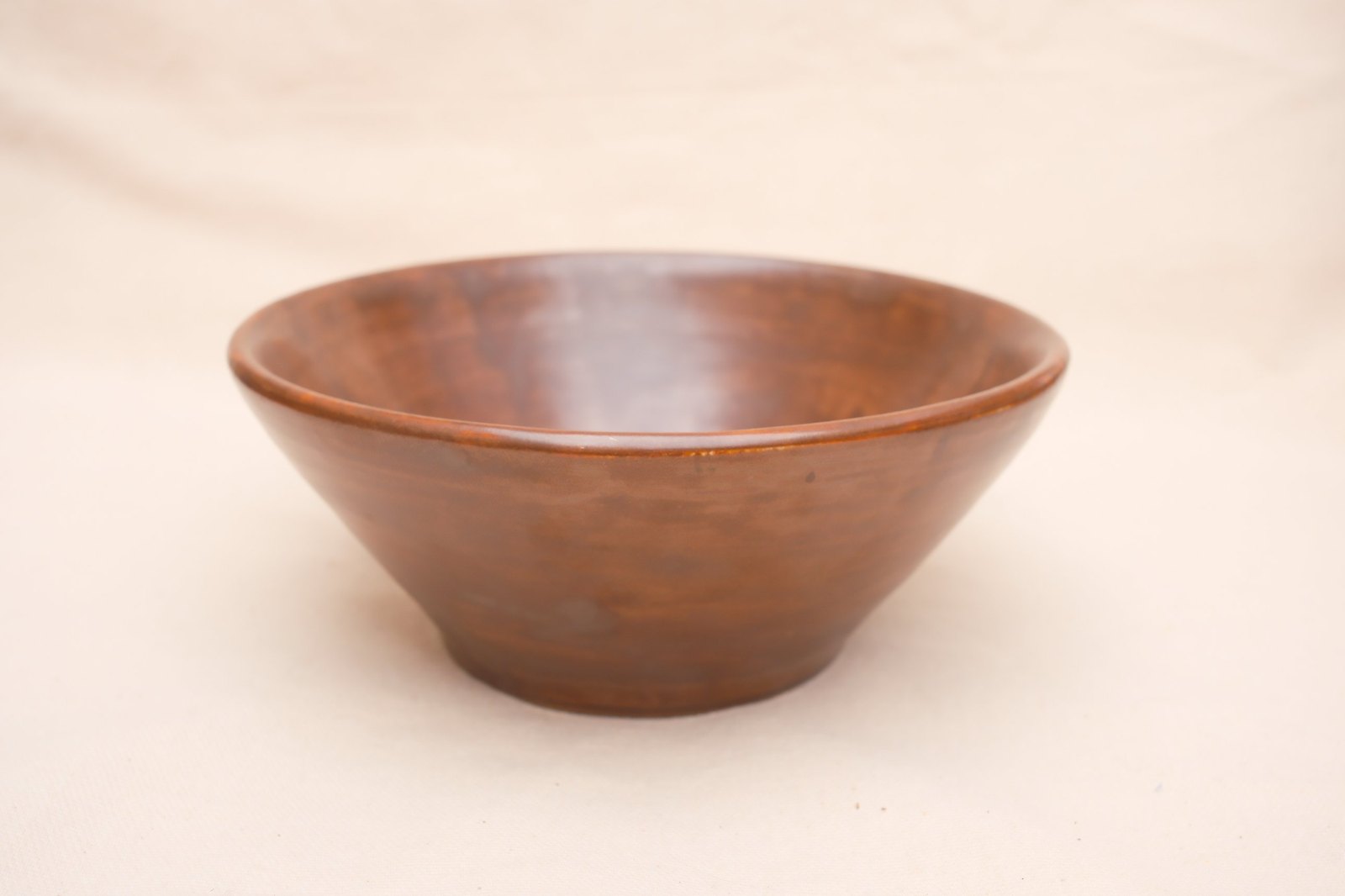 The bowl straight on, its flared walls and narrow foot