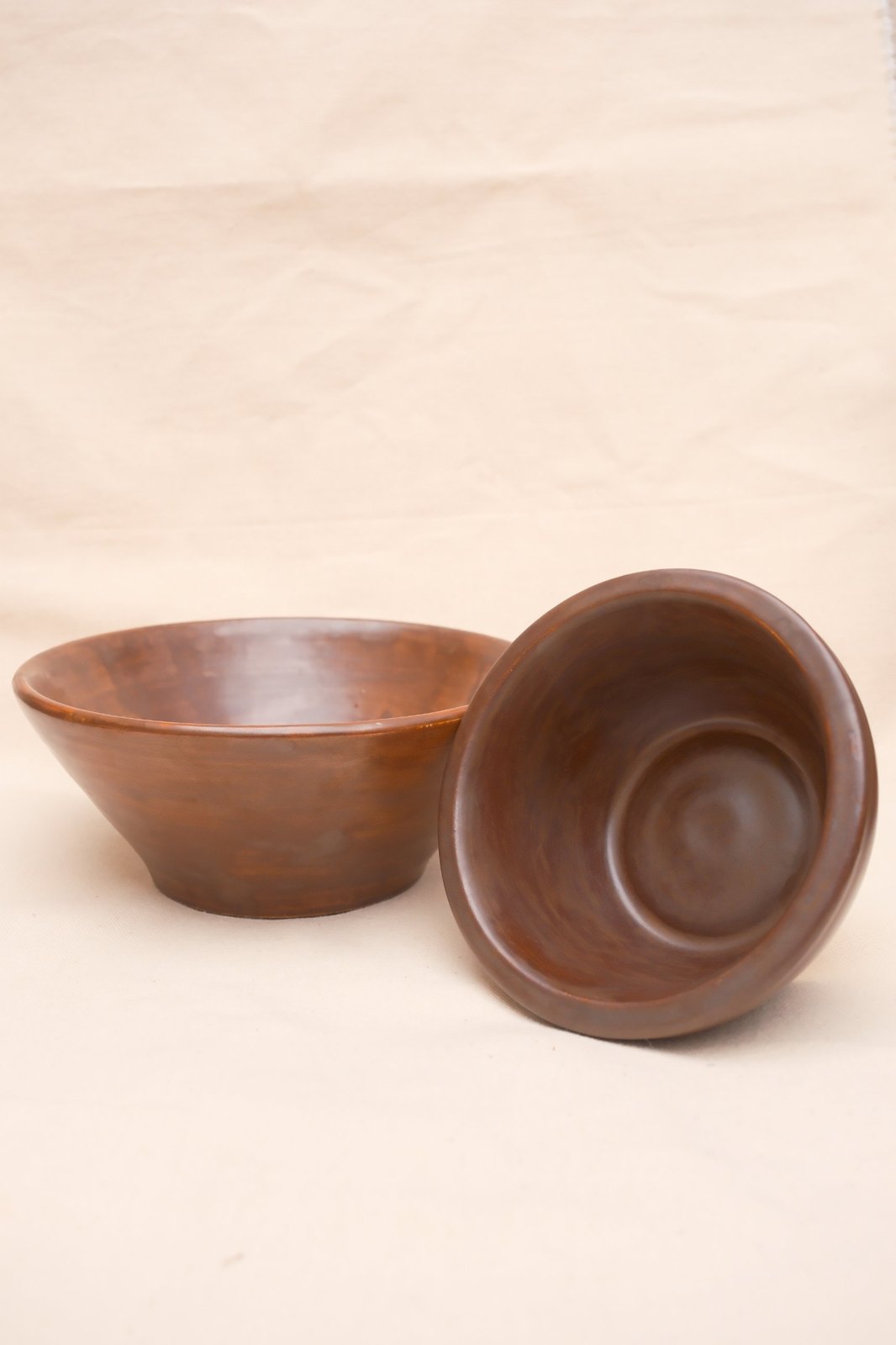 The flared bowl beside the small bowl tipped to show its inside
