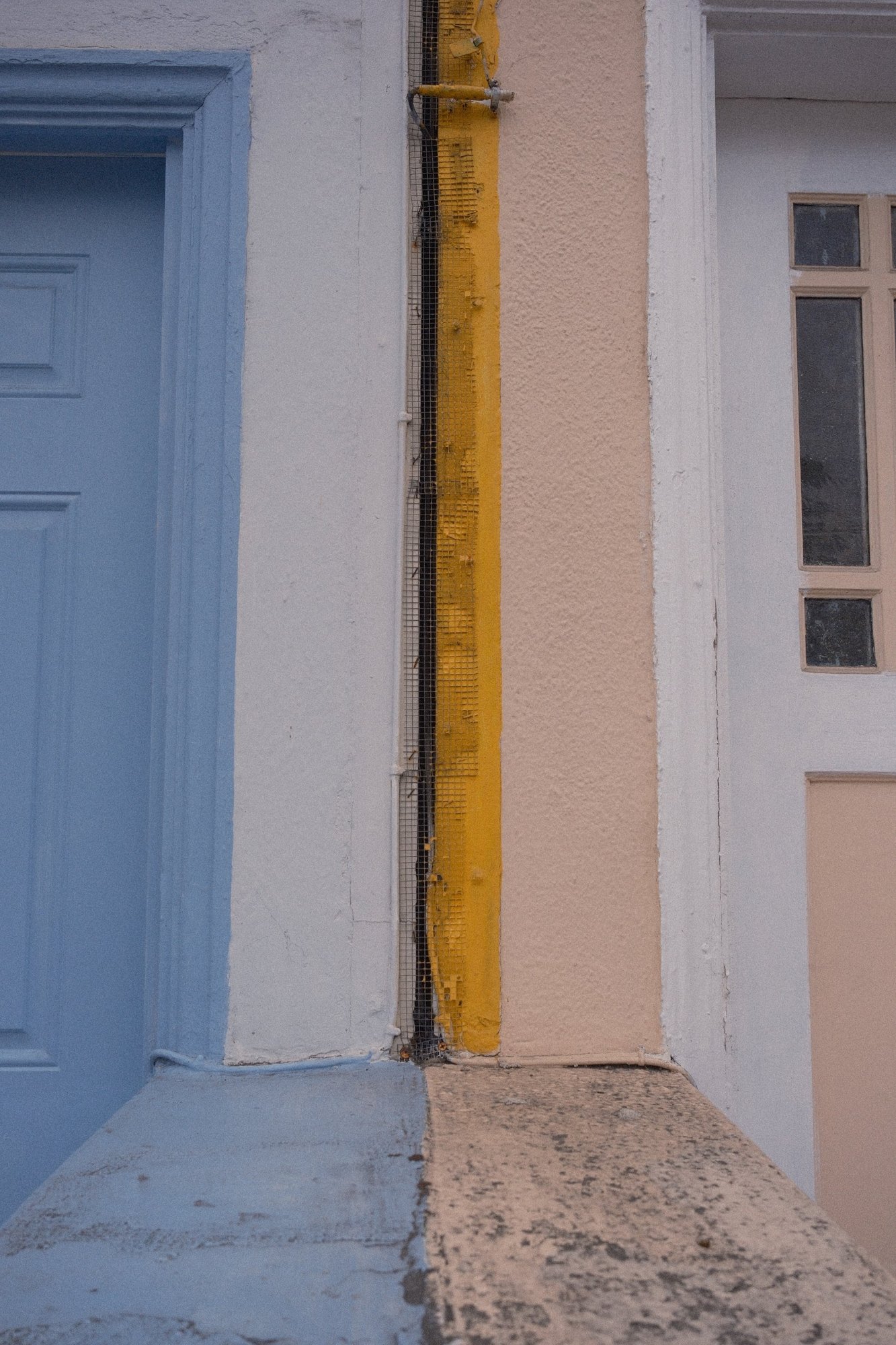 Where two houses meet: powder blue, a stripe of yellow, then peach