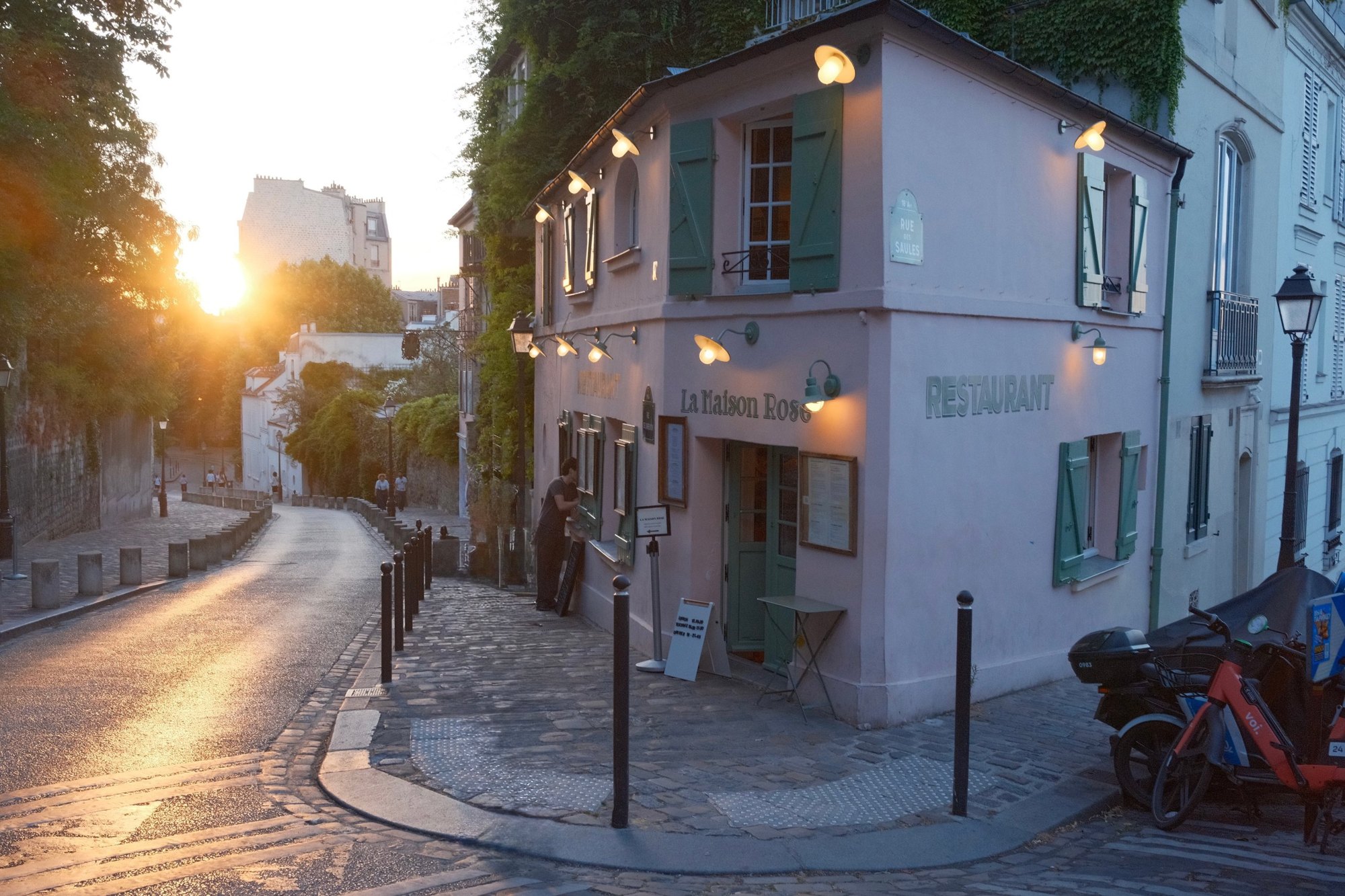 Sunset pouring down Rue des Saules beside the pink La Maison Rose