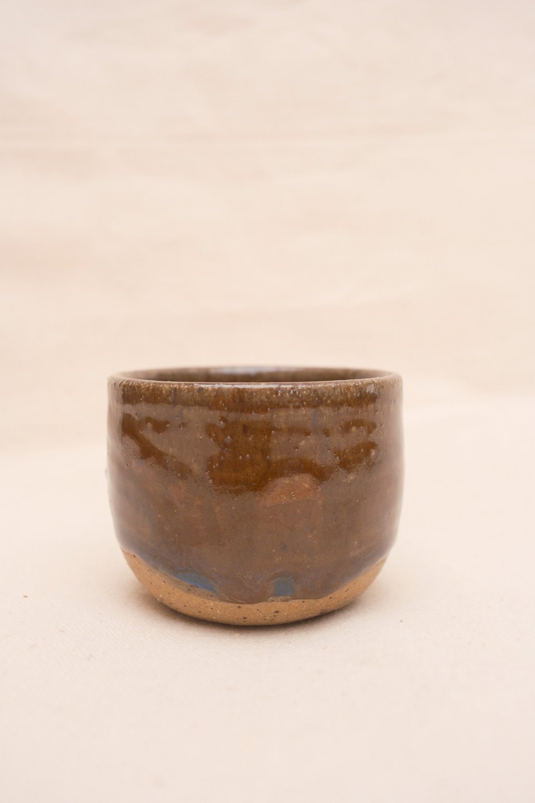 Amber espresso cup, No. 01: glossy amber-brown glaze over a speckled clay foot