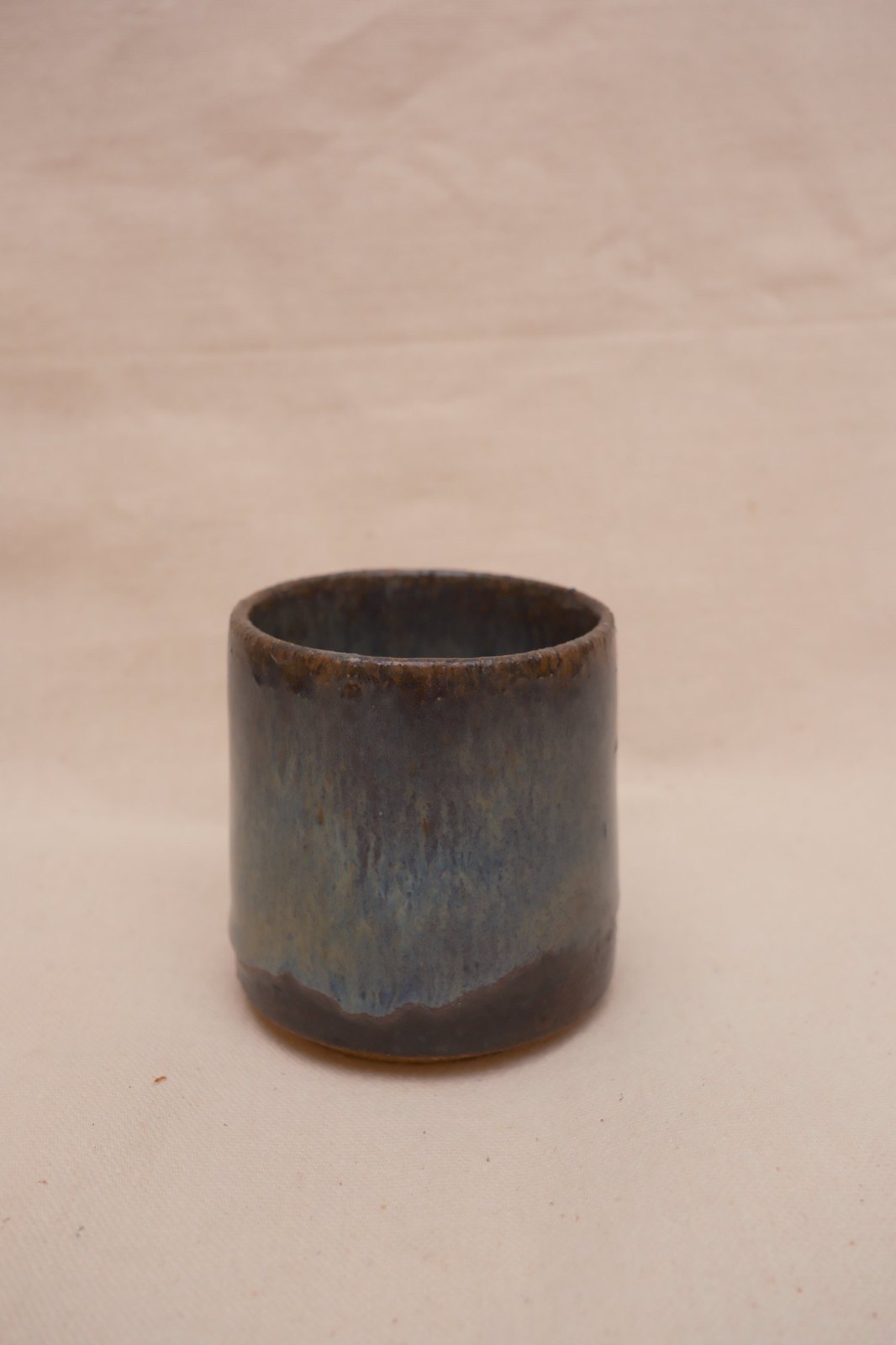 The second cup, glaze running in fine streaks to a dark line near the foot