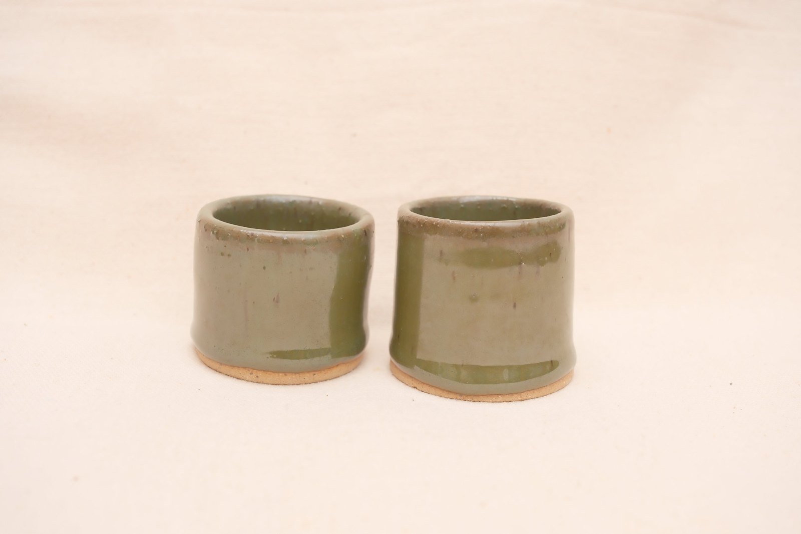 Two shot glasses straight on, showing the slight difference in their shapes