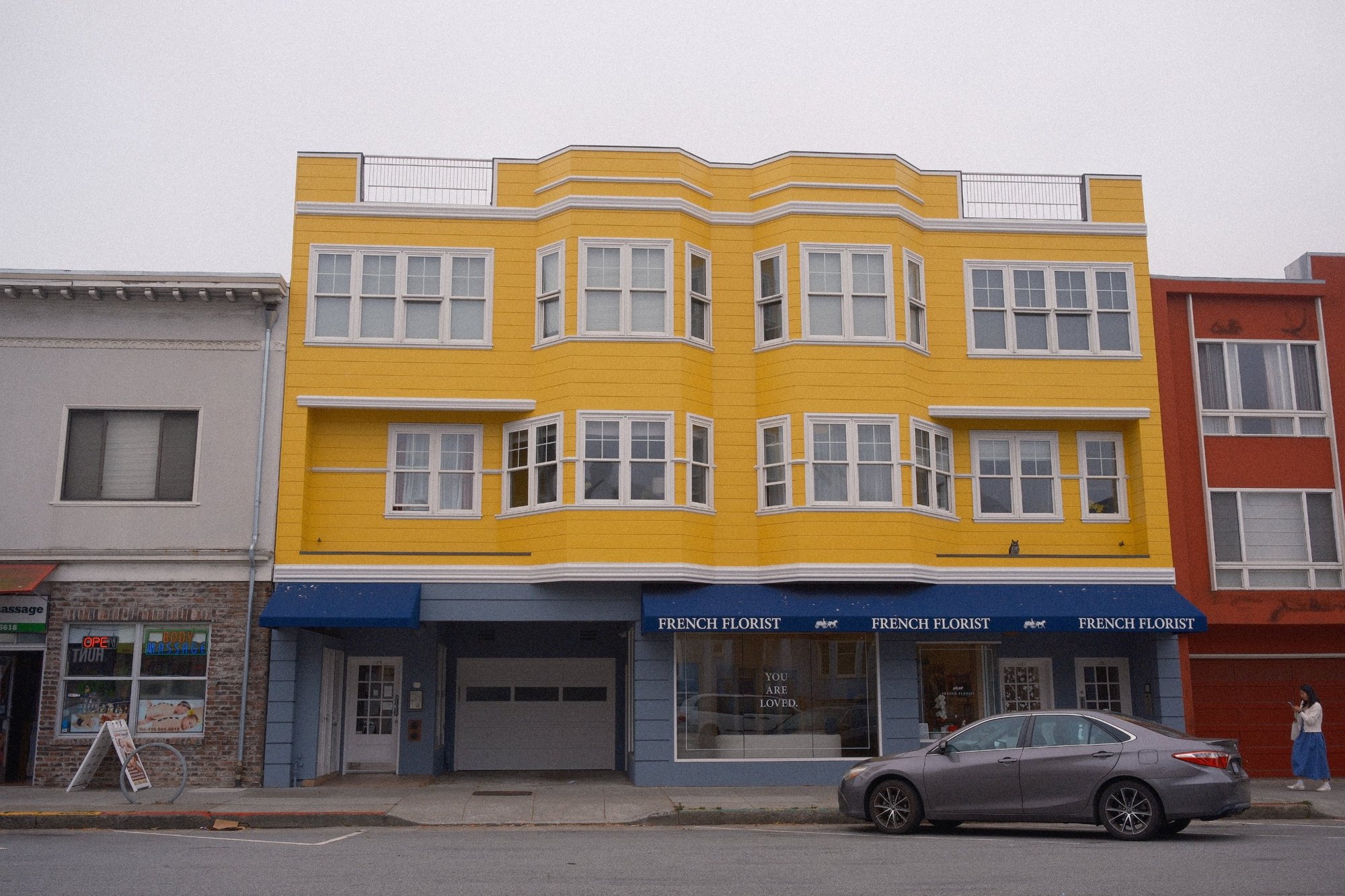 The bright yellow French Florist building with its navy awning