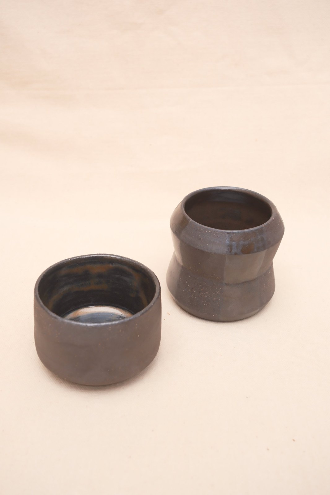 The pair on linen, the short cup in front