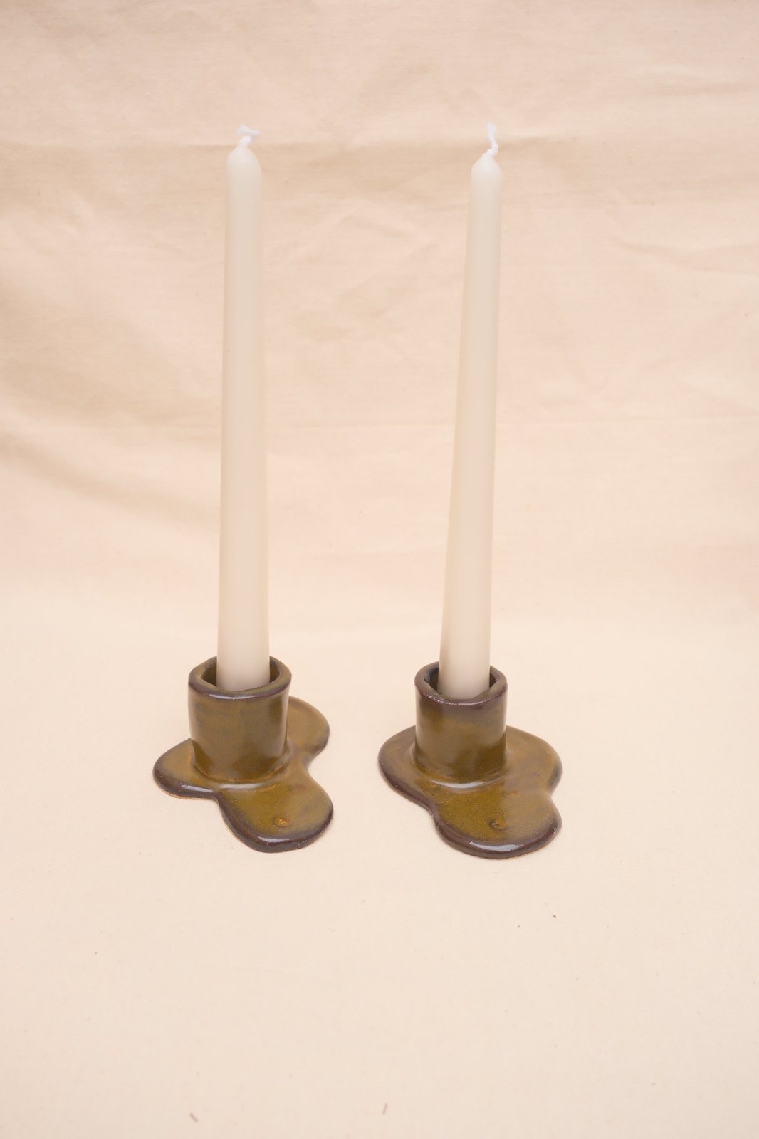 Both holders with tall taper candles, from a slightly raised angle