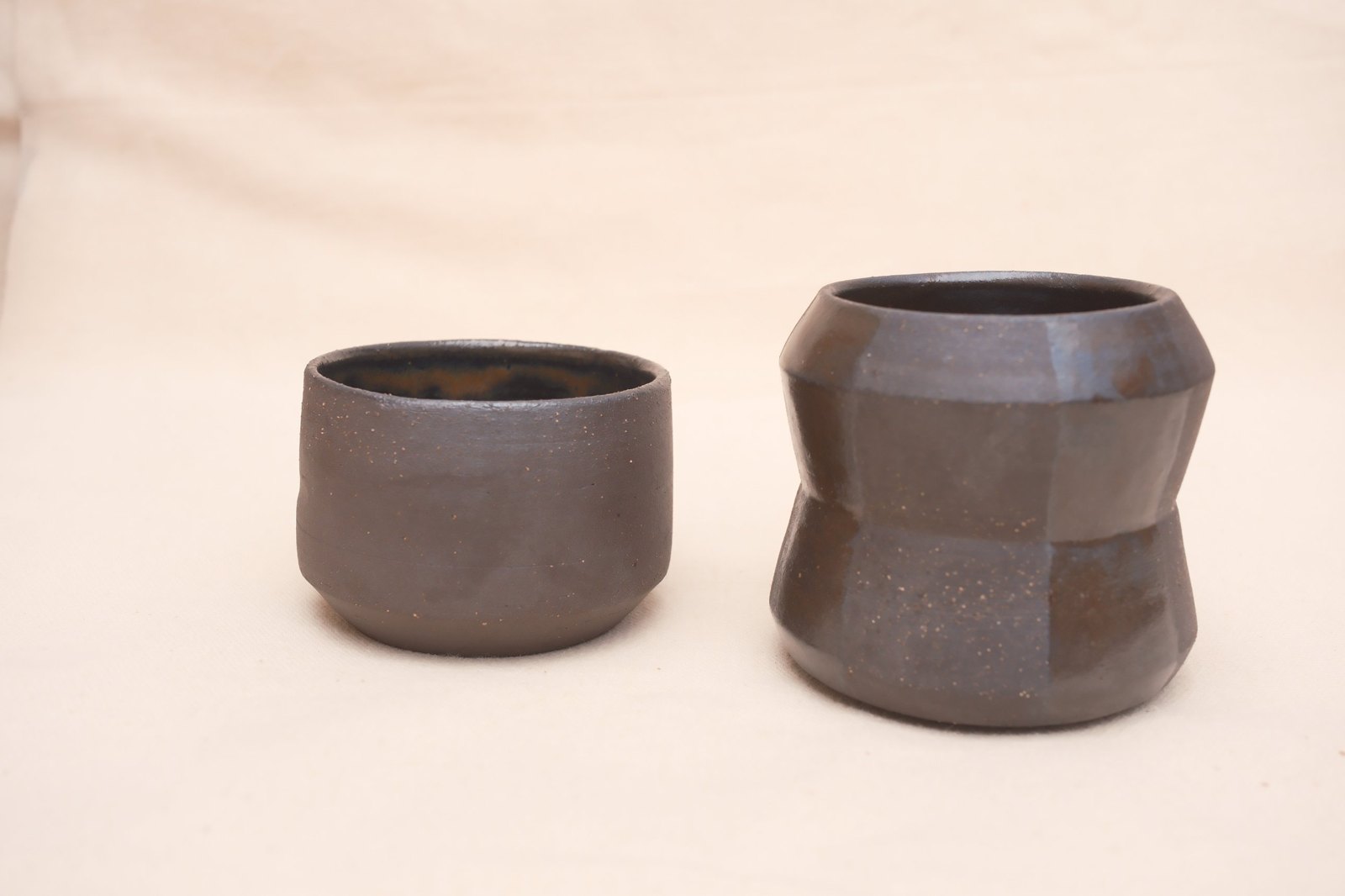The short espresso cup beside the taller striped flat white cup