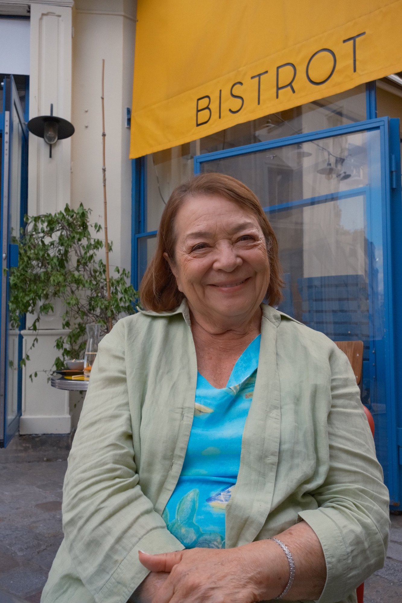 A warm smile beneath the yellow Bistrot awning