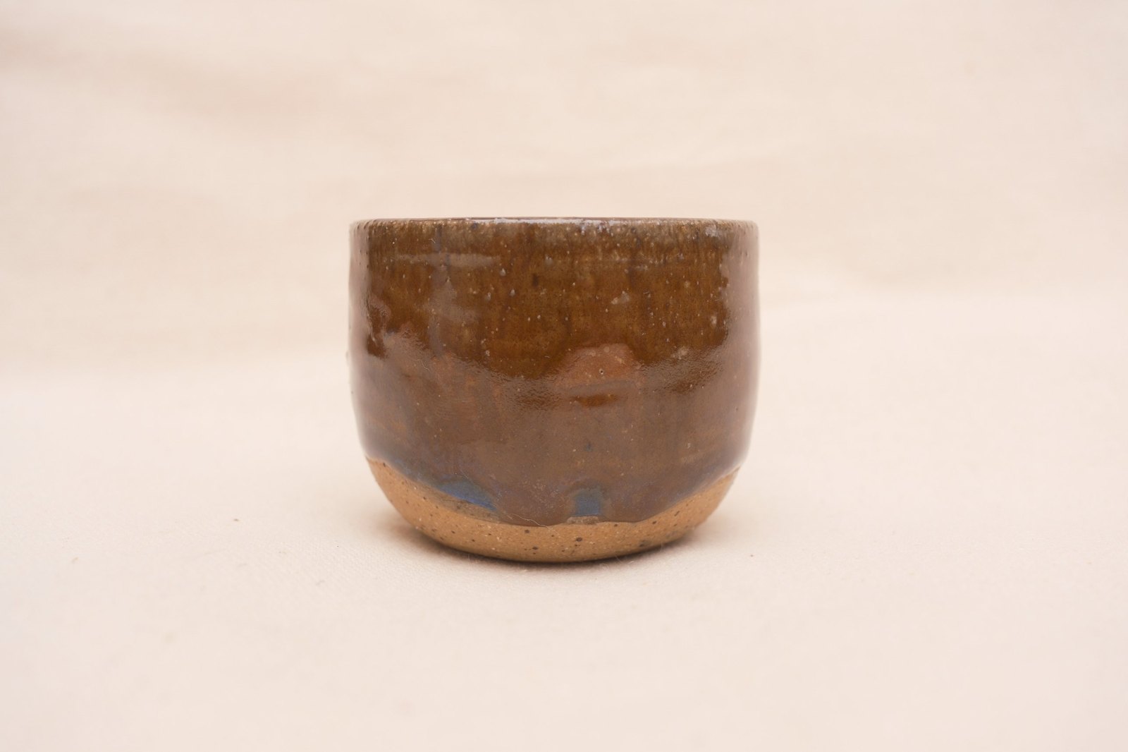 Amber cup straight on, showing the blue break where the glaze meets the bare foot