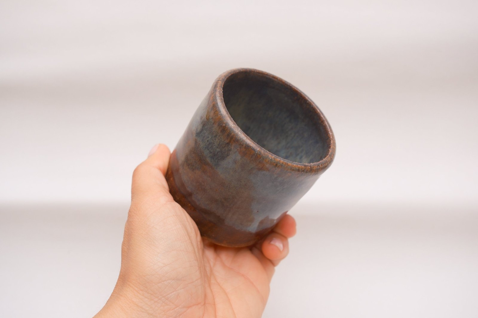 A cup tipped in the hand to show the interior