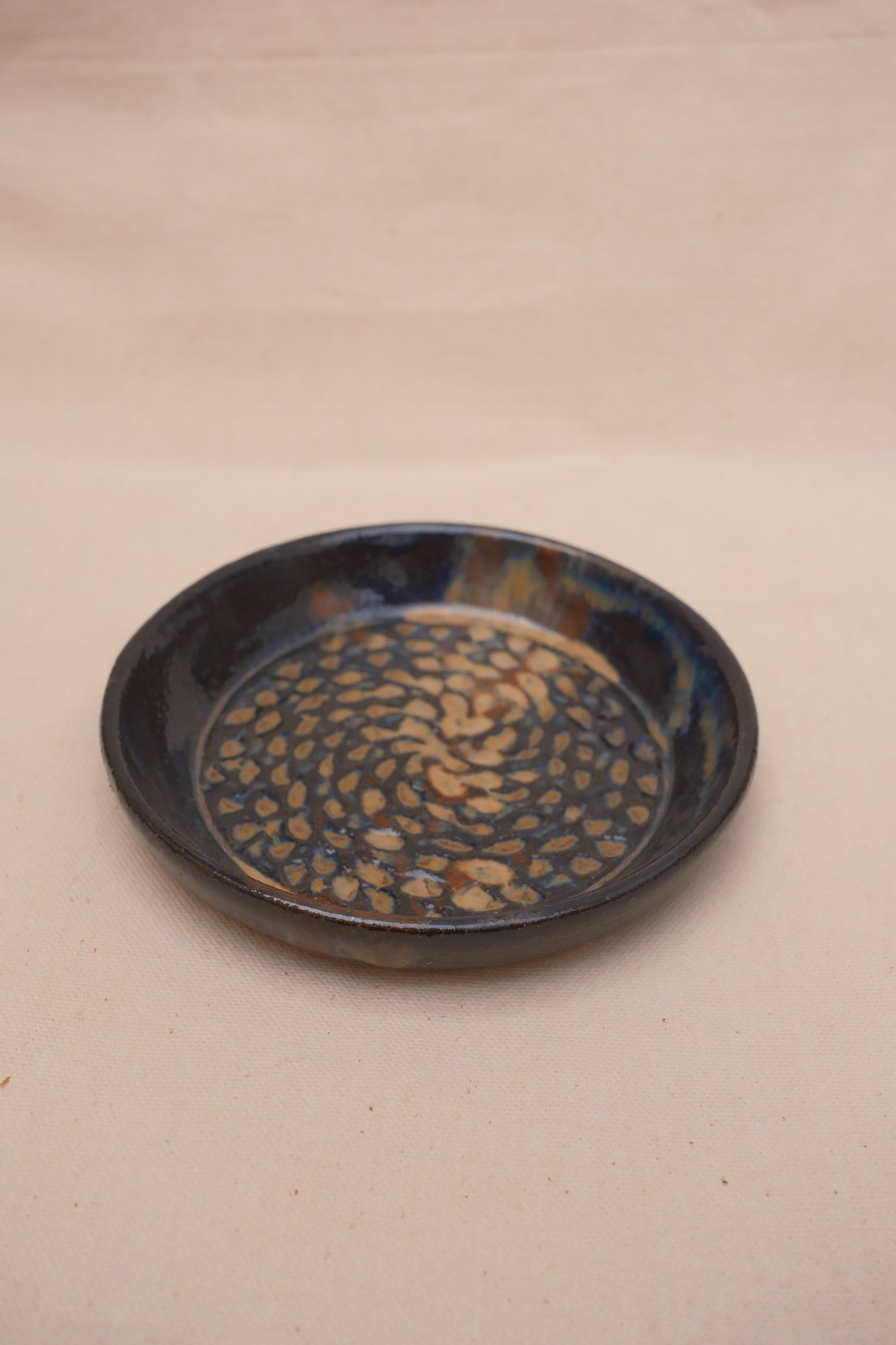 Textured dish, No. 11: Tiger's Eye and Opal Lustre over a pressed spiral pattern