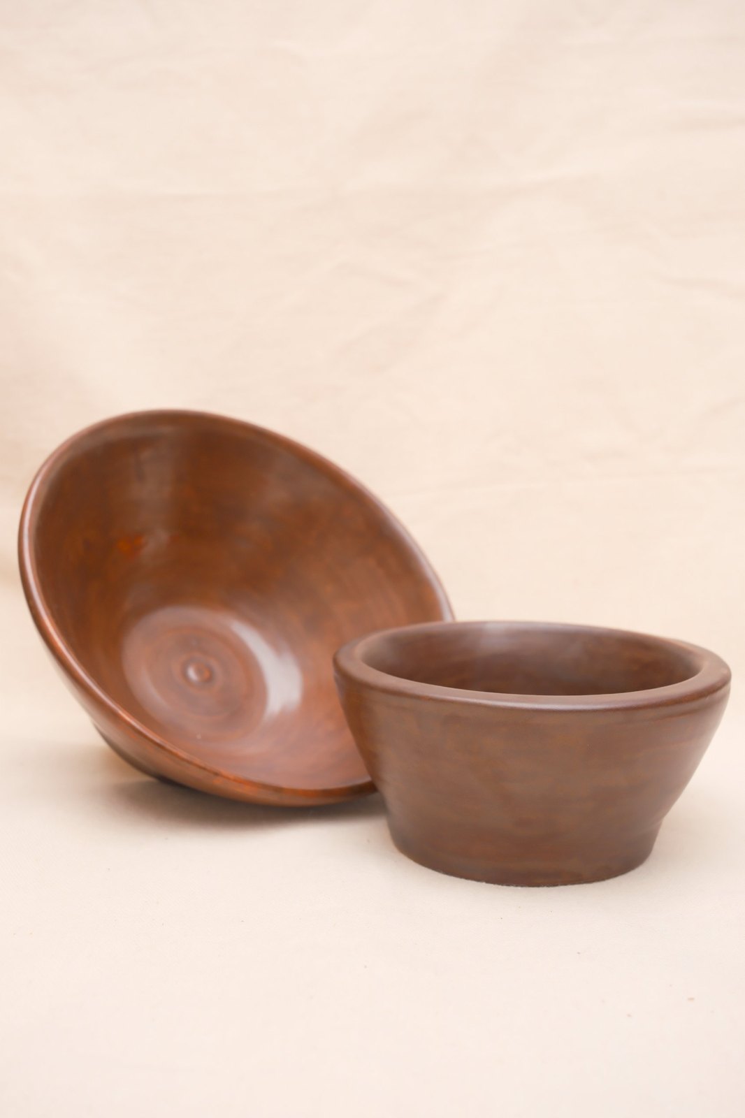 The flared bowl tipped on its side behind the small bowl