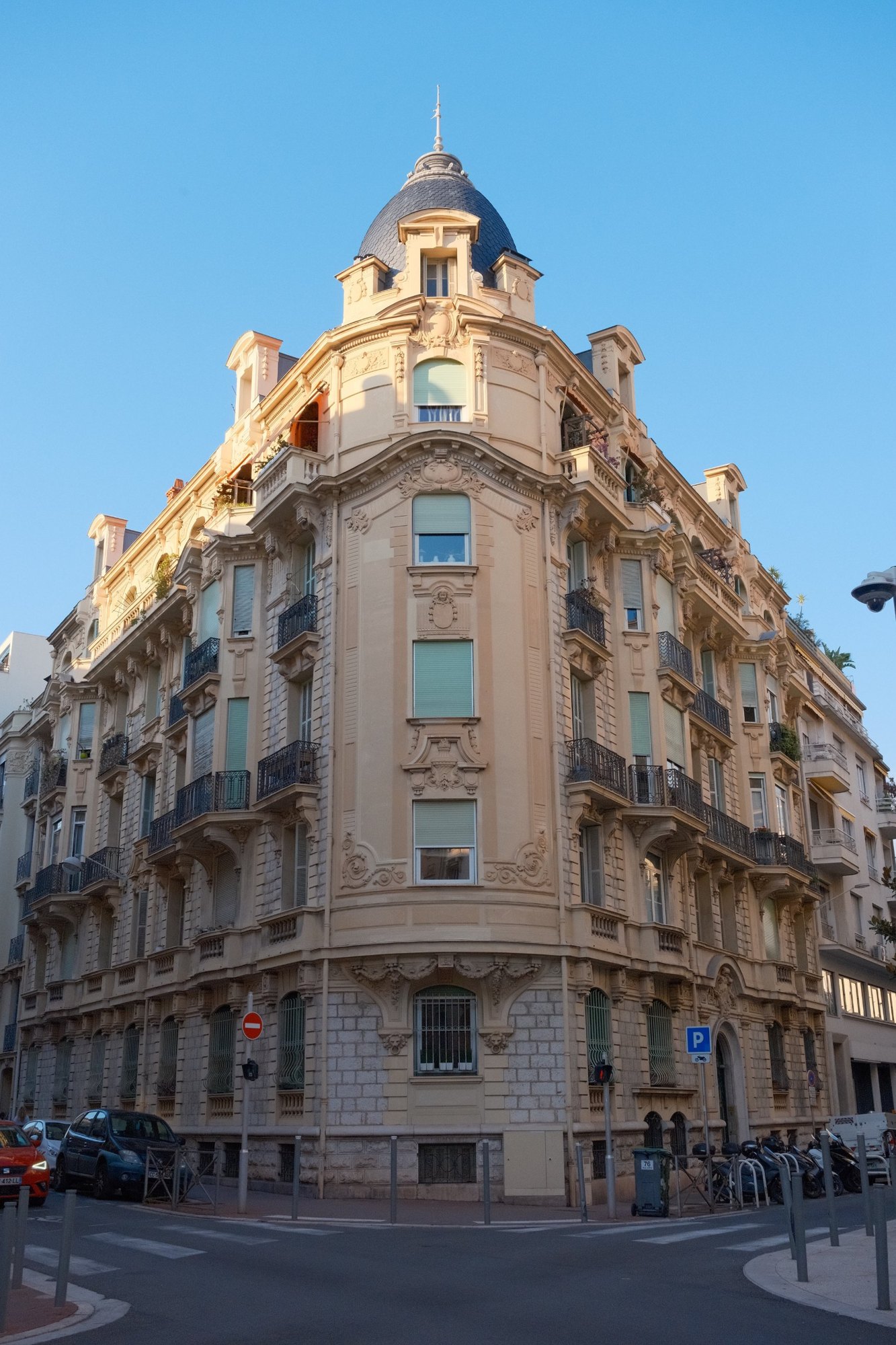 A Belle Époque corner building with a slate dome, glowing in late sun