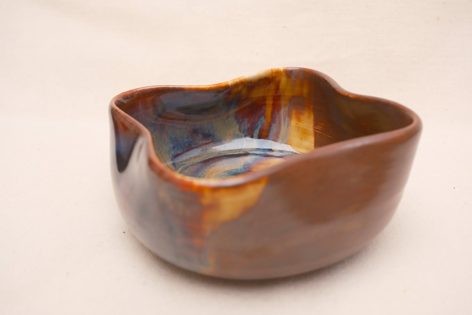 The bowl from the side, glaze breaking blue down the outside
