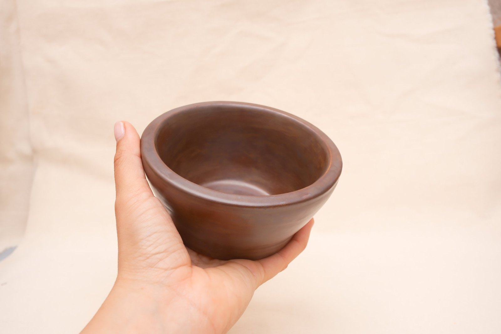 The bowl cupped in one hand, showing its size