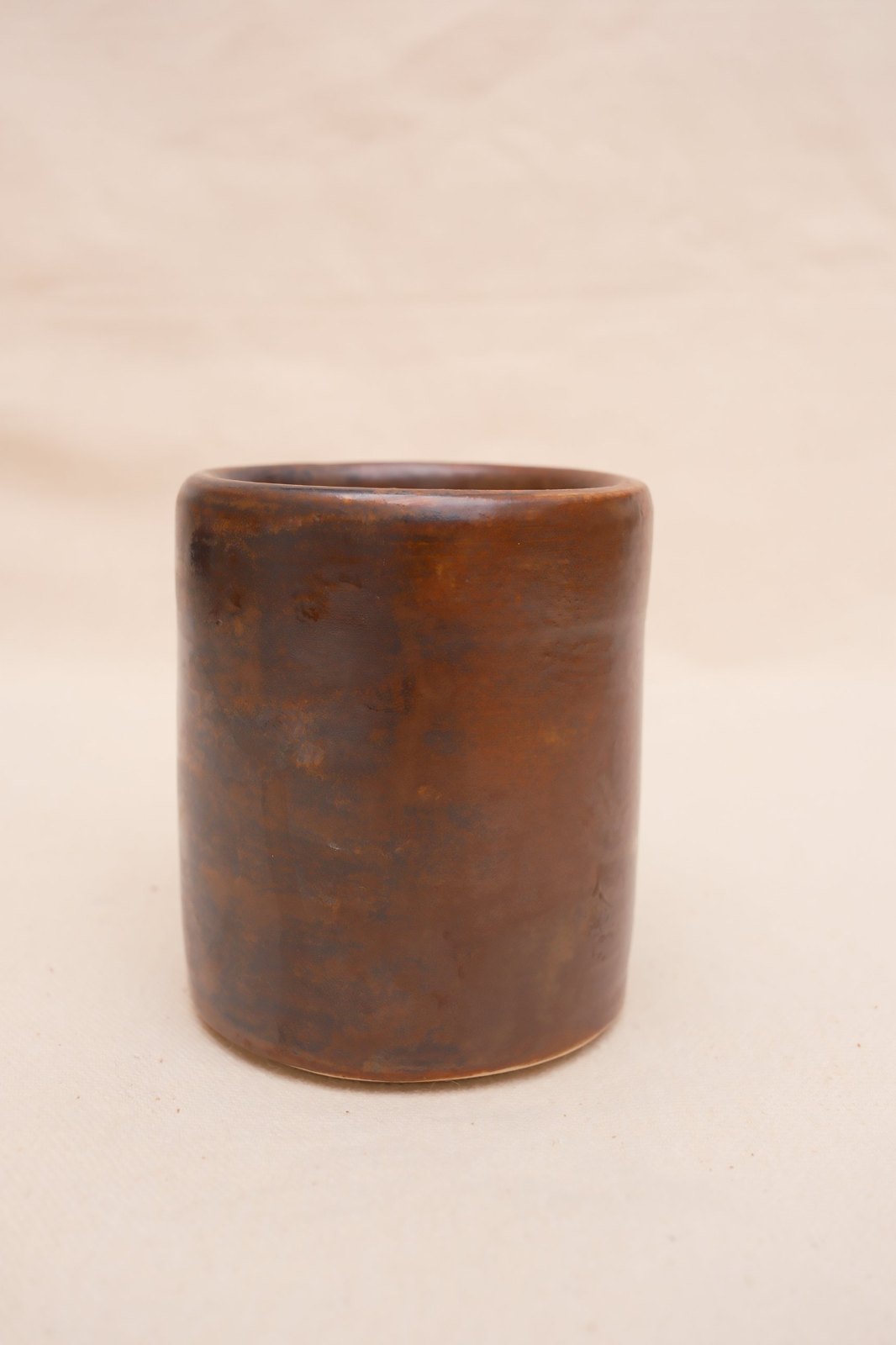 The cup straight on, deep brown with amber streaks