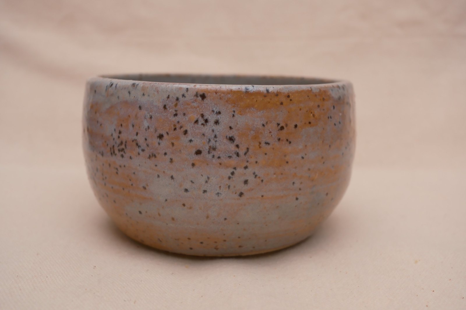 Close side view of the speckles and pink-blue glaze