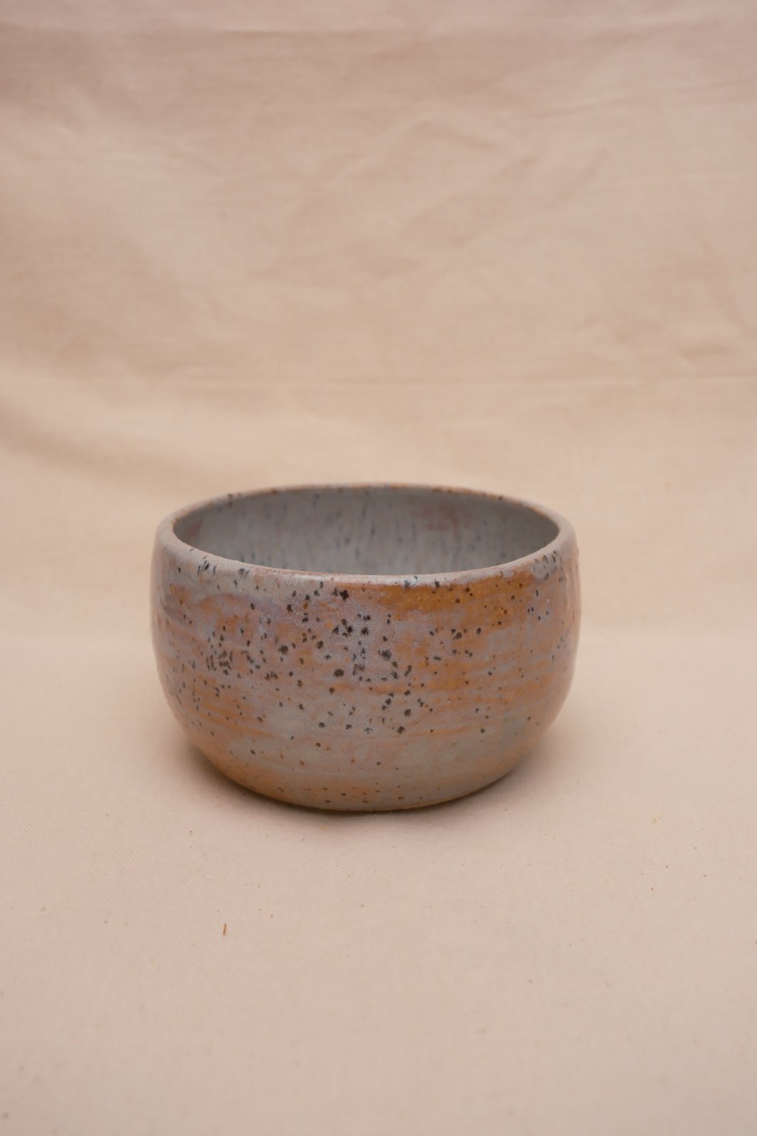 The bowl straight on, warm clay showing through the glaze