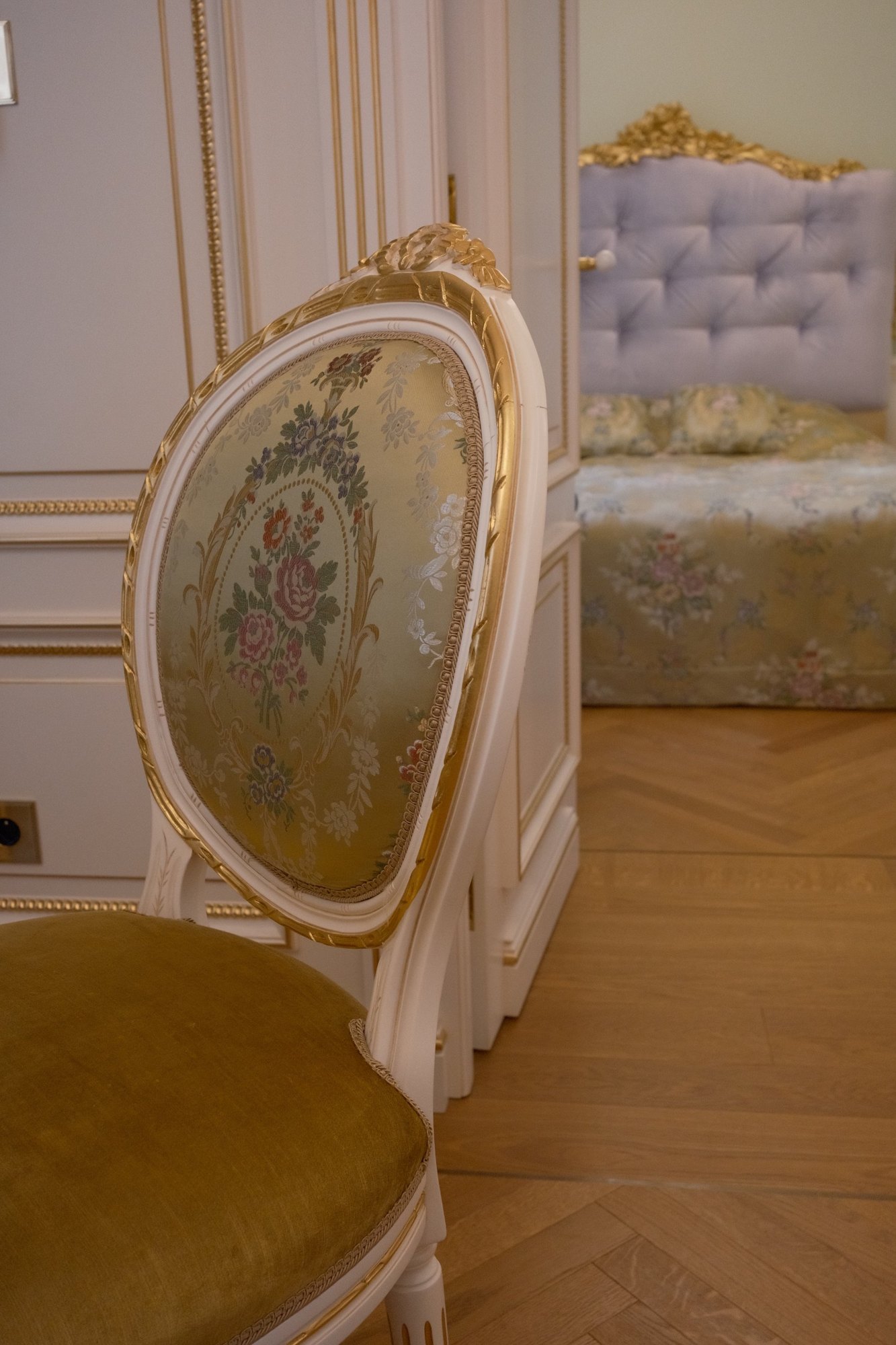 A gilded medallion chair in floral silk, the lavender bed beyond